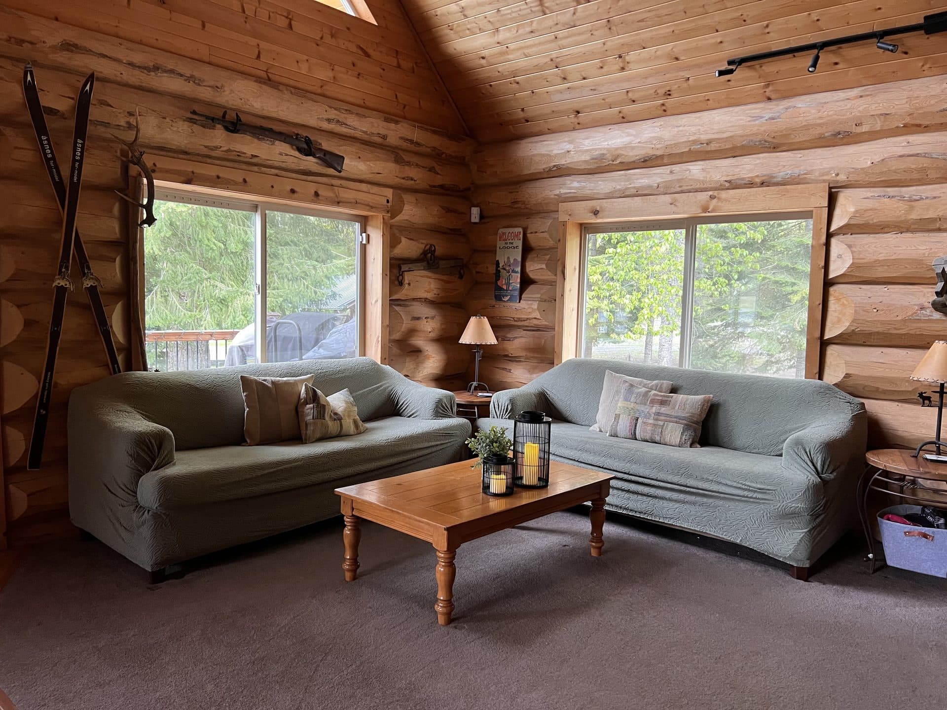 Log lodge living room with vaulted ceiling and cozy couches at Alpine Lakes Lodge