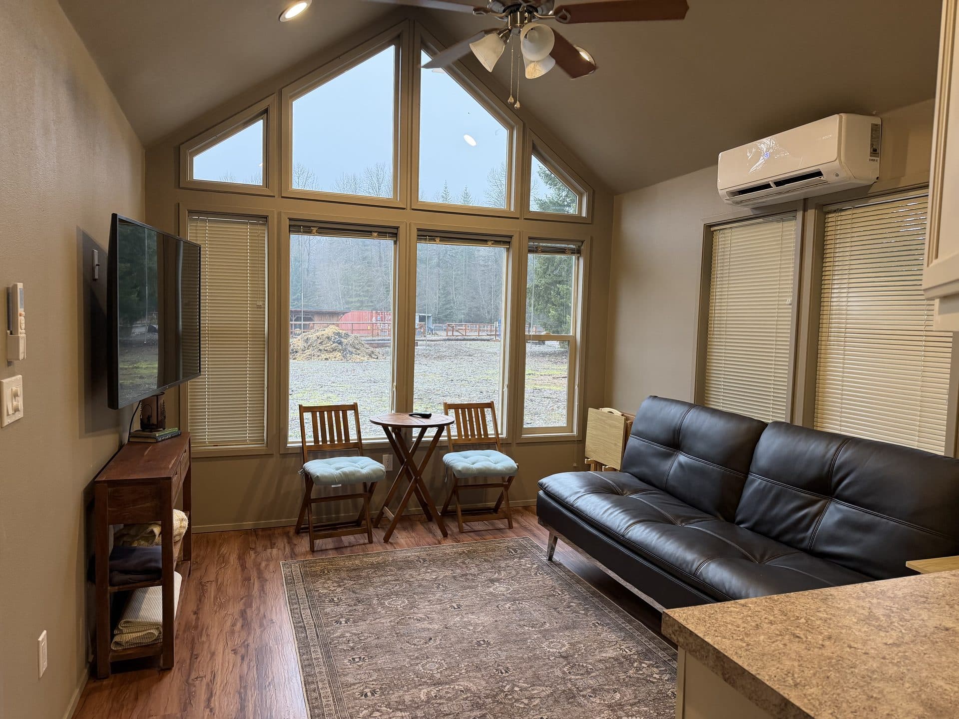 Modern tiny home with floor-to-ceiling windows and hardwood floors at Alpine Lakes Lodge